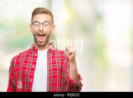 Young handsome man over isolated background pointing finger up with successful idea. Exited and happy. Number one. Stock Photo