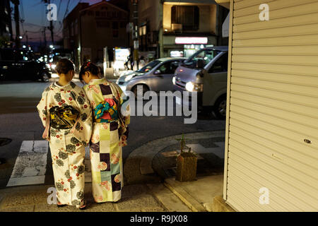 Japanese women in traditional clothes walking on Kyoto streets, Japan Stock Photo