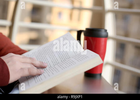 Man is reading book with water bottle on the table. Stock Photo