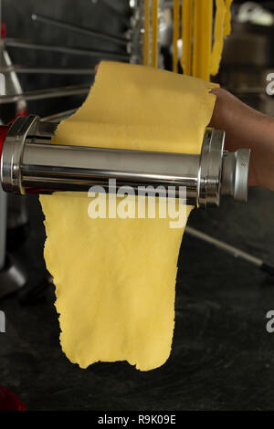 producing fresh pasta with a pasta machine Stock Photo
