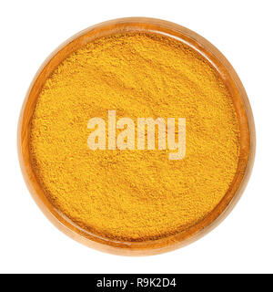 Curry powder in wooden bowl. Orange spice mix, made of different ingredients, most recipes include coriander, turmeric, curcuma, fenugreek, and chili. Stock Photo