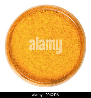 Turmeric powder in wooden bowl. Deep orange spice, used as coloring and flavoring agent for curries. Processed and ground rhizomes of Curcuma longa. Stock Photo