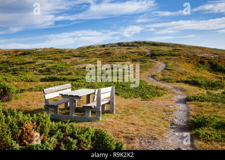 Wooden picnic table with benches by a mountain hiking trail in Oppland County of Eastern Norway, Scandinavia Stock Photo