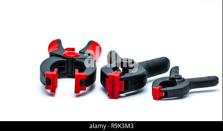 Black and orange spring clamp isolated on white background. Set of small, medium, and big size of plastic clamp. Clamping tools for carpentry work. Ha Stock Photo