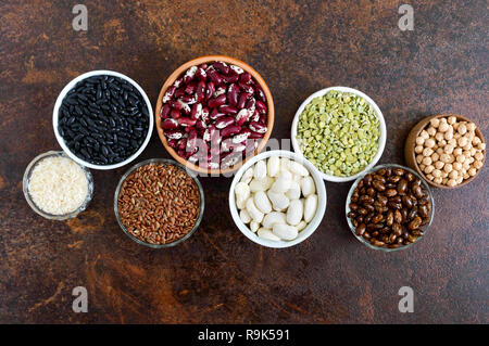 Healthy food, dieting, nutrition concept, vegan protein source. Assortment of colorful raw legumes: green peas, beans, chickpeas, rice in bowls. Stock Photo