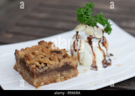 Granny Smith apples crumble pie with cinnamon and spices, and a scoop of vanilla ice cream. Stock Photo