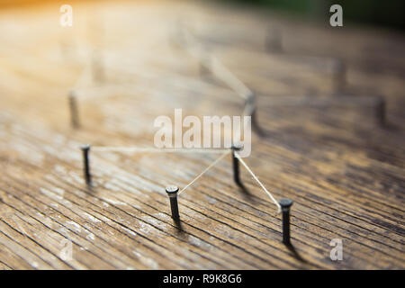 Connecting networks concept - network connected with yarn white on Plank wood with copy space. Simulator connection social media, internet, people com Stock Photo