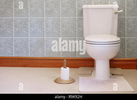 Victorian toilet pan cistern close coupled lever flush white and gold wooden paper holder Stock Photo