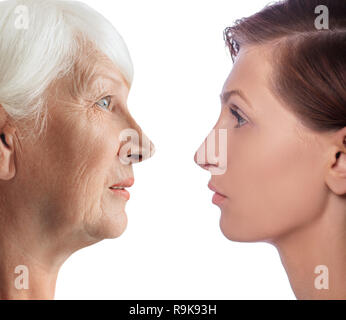 Showing aging process. Faces young women and aged woman. Comparison female faces, aging process Stock Photo