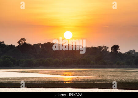 Sunset in the lake. beautiful sunset behind the clouds above the over lake landscape background. dramatic sky with cloud at sunset Stock Photo
