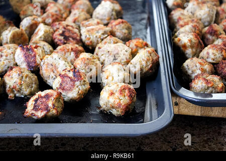 Freshly baked meatballs about to be taken off a cookie sheet