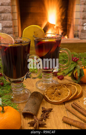 Christmas drink. Cozy fireplace concept. Mulled wine , star anise and cinnamon sticks, cookies, choocolate, tangerine and Christmas tree branch on bro Stock Photo