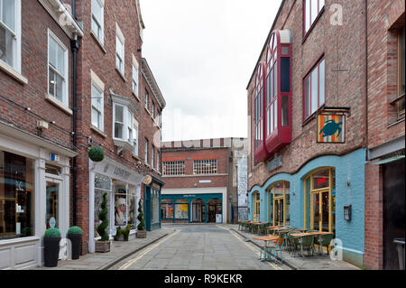 York, England - April 2018: Old brick buildings housing shops and restaurants on alley of Little Stonegate in historic district of City of York, Engla Stock Photo