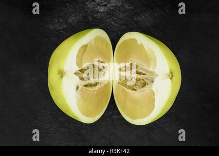 Top view of divided in the half pomelo fruit and placed on black stone background surface Stock Photo