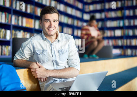 Handsome student guy in modern library Stock Photo