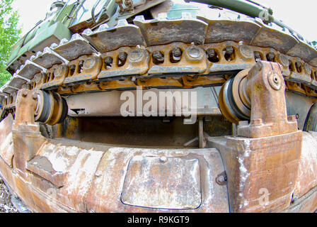 Close-up of mud covered bulldozer tracks of a yellow industrial earth excavator machine Stock Photo