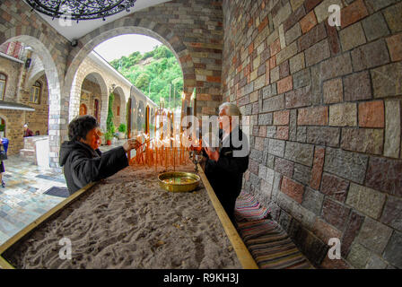Lighting candles in a monastery in Greece Stock Photo