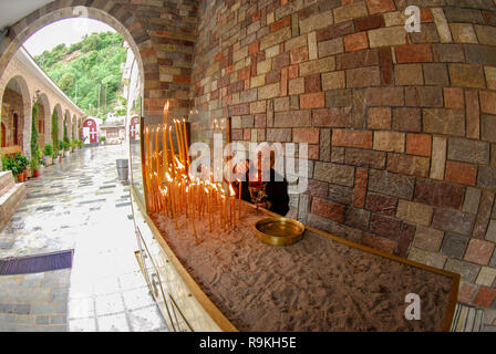 Lighting candles in a monastery in Greece Stock Photo