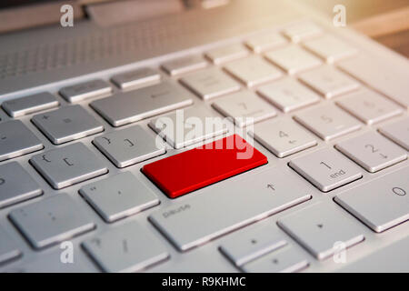 Keyboard with red blank Enter button modern pc text communication board. .Color button on the gray silver keyboard of modern ultrabook. Stock Photo