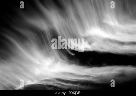 Cirrus clouds spreading out over sky creating bird wings, animal shapes Stock Photo