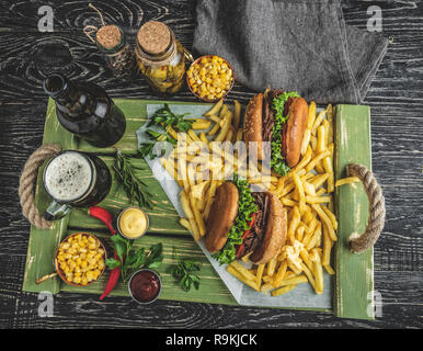 Barbeque pulled beef sandwich, burger, french fries, sauce, dark beer, corn on a wooden tray Stock Photo