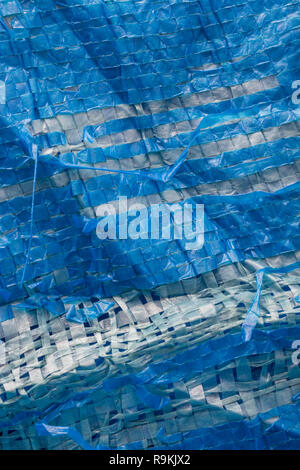 Macro-photo of very worn blue cheap Poly-Tarpaulin - exposed inner woven plastic fabric laminated with blue LDPE / Low-density Polyethylene. Stock Photo