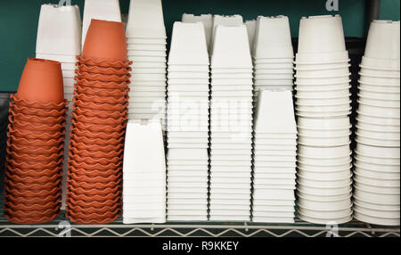 Plastic white flower pot and orange terracotta pot for plant and flower in garden Stock Photo