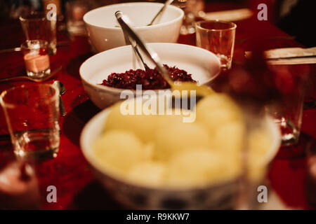 bowl of dumplings and red cabbage on a table ready laid for Christmas dinner Stock Photo