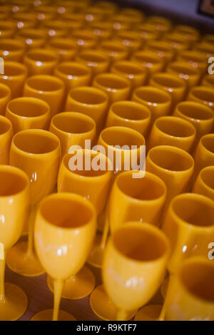 Many yellow plastic wine glasses on a table. Stock Photo