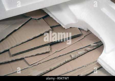Background image with a lot of beige cardboard paper and styrofoam boxes disgarded as rubbish. The concept of unpacking new home appliances out of the Stock Photo