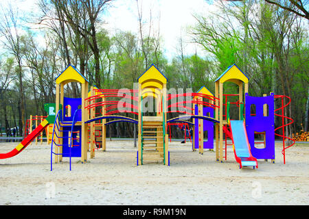 Childish playground in city park. Swing carousel in park for children. Children's playground bright multicolored. Modern playground for kids in city p Stock Photo