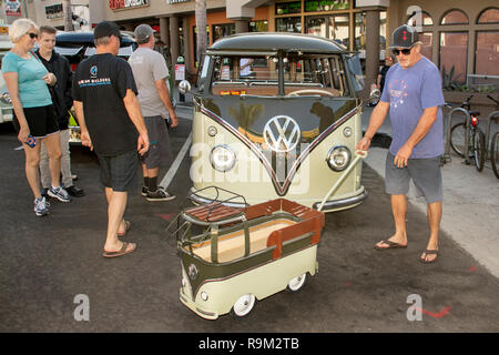 The owner of a classic 1961 Volkswagen van shows off a junior-size mascot in the form of a wagon replica of his vehicle at an antique car show in Huntington Beach, CA. Stock Photo