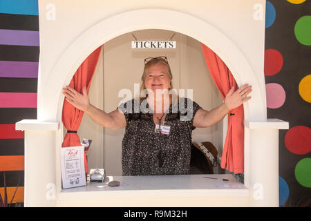 A volunteer ticket seller makes customers feel welcome at the window of a booth at an art fair in Laguna Beach, CA. Stock Photo