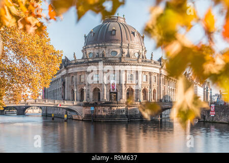 Bode museum in autumn mood. Museum Island in Berlin, capital of Germany, on sunny day with the River Spree and leaves from the tree on a bridge