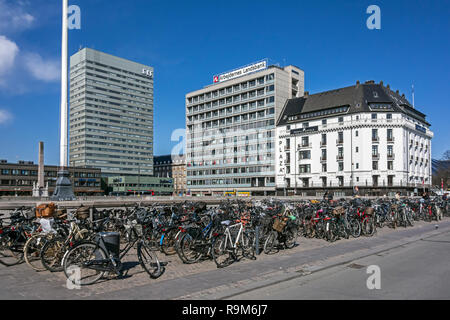 Bicycles outside the central railway station in Copenhagen Denmark  with the Radisson Collection Royal hotel, arbejdernes landsbank HQ & Plaza Hotel Stock Photo