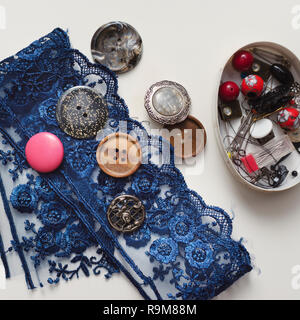 Tools and accessories for sewing on light wooden background. Stock Photo