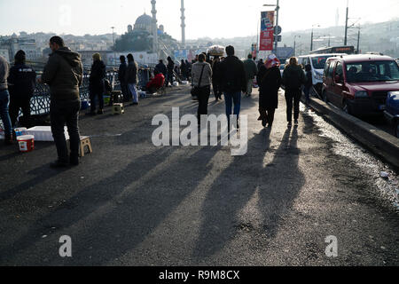 Istanbul, Turkey - December 22, 2018 : Some Turkish People are walking on The Galata Bridge with nice shadows, others are fishing. Stock Photo