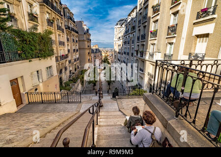 People sitting down with sketch pads on Rue du Mont Cenis Stairs, a  series of steep steps in Montmartre, Paris, France Stock Photo