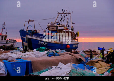 Hastings,  East Sussex, UK. 26th Dec, 2018. A brief glimpse of the sun on the fishing boat beach at sunrise on a mild overcast Boxing Day morning. Stock Photo