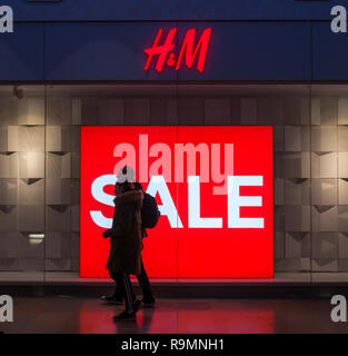 Couple walking past window display in clothes shop smiling carrying Stock Photo: 11883008 - Alamy