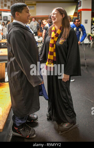 Wearing wizard's robes and scarfs in Hogwarts House colors, two Harry Potter devotees chat at an ice skating event in honor of Potter author J.K. Rowling in Anaheim, CA. Stock Photo