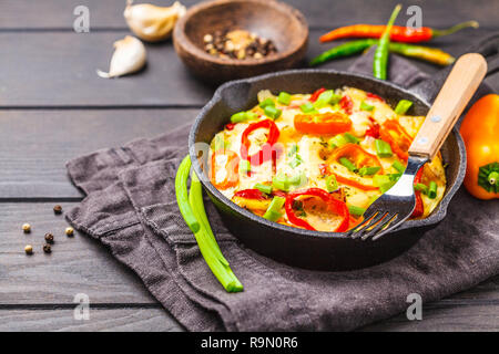 Traditional fritatta with peppers and potatoes. Dark wooden background Stock Photo