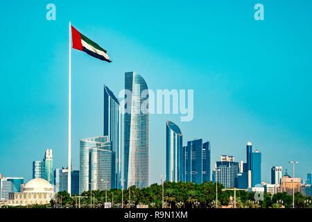 The photo shows the skyline of Abu Dhabi, taken from seaside. A AEU flag is waving in the foreground. Stock Photo