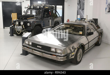 1981 DeLorean DMC-12 from Back to the Future Part 2, and Land Rover Defender 110 HCPU from Tomb Raider. British Motor Museum, Gaydon, Warwickshire, UK Stock Photo