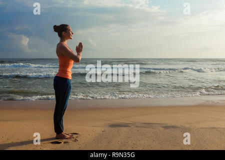 Woman doing yoga on beach Stock Photo