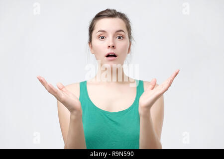 Stupefied emotive woman reacts on sudden news from friend isolated over white background. Astonished girlfriend stares at camera Stock Photo