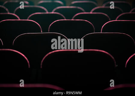 Seats in the cinema illuminated by the light from the screen. Stock Photo