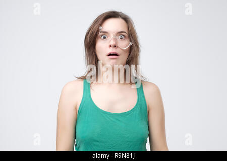 Upset handsome woman tired of wearing glasses. Sad young femalr failing in putting on eyeglasses. Stock Photo