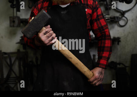 Big hammer in hands of smith Stock Photo