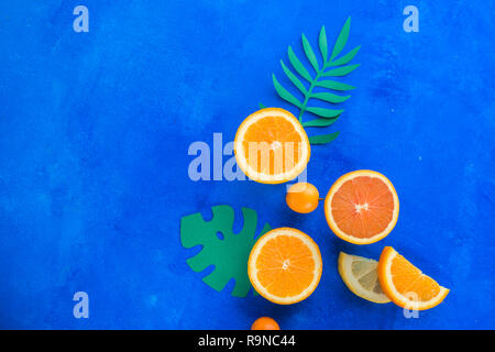 Exotic fruits close-up. Oranges, kumquats and other tropical fruits vibrant blue background with copy space. Stock Photo